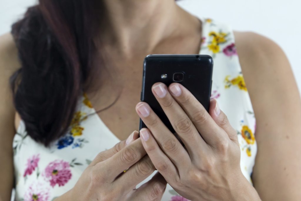 Una usuario de redes sociales revisa su móvil con atención. ¿Pensará que parte de su identidad compartir allí?